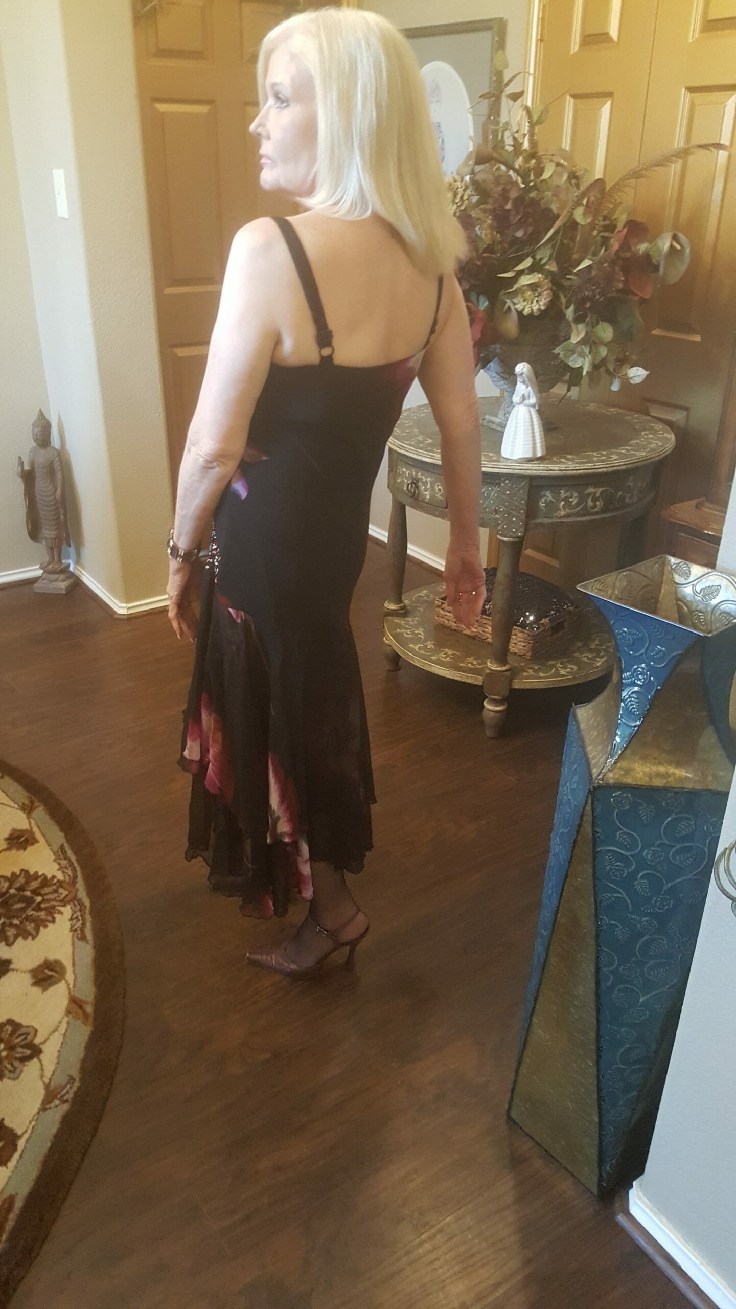 Back view of a Midnight Velvet customer, in a black and magenta floral print dress with skinny straps.