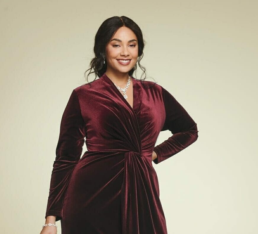 plus size model wearing a burgundy velvet dress with silver metallic pumps