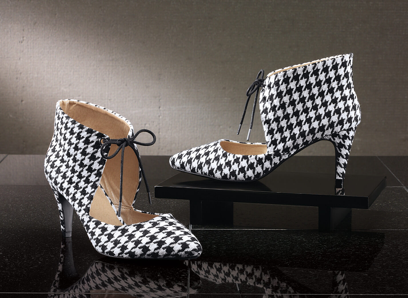 Covered in a black-and-white houndstooth print from heel to pointed toe, this tie-front shoe makes a bold statement.