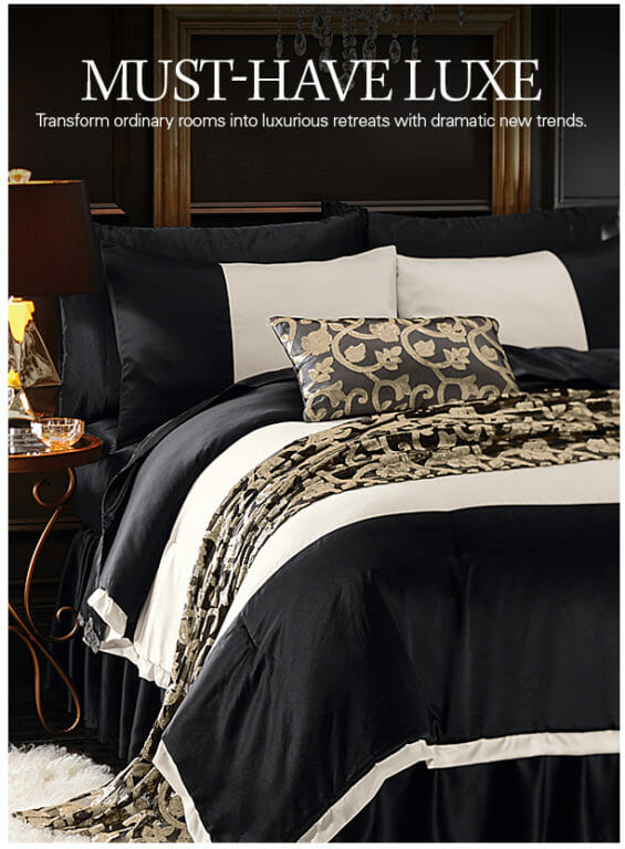 Must-Have Luxe, Black and white bedding with a jacquard throw and matching toss pillow, next to a scrolled side table.