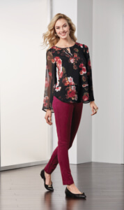 Model wearing a floral tunic with sheer sleeves and brick colored faux suede leggings