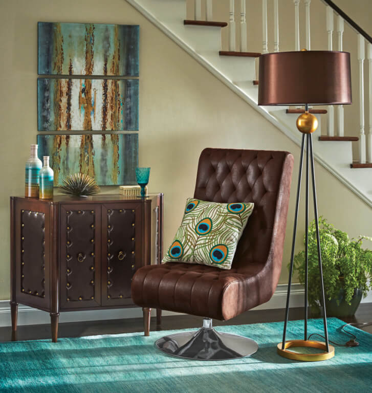 Upholstered armless tuffed swivel chair with a gold and brown tripod floor lamp