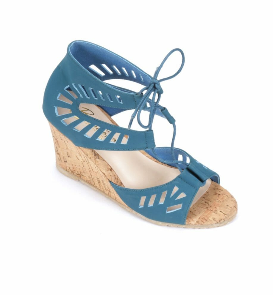 A single cork wedge sandal with a light denim blue cutout upper and a blue cord that ties in front.