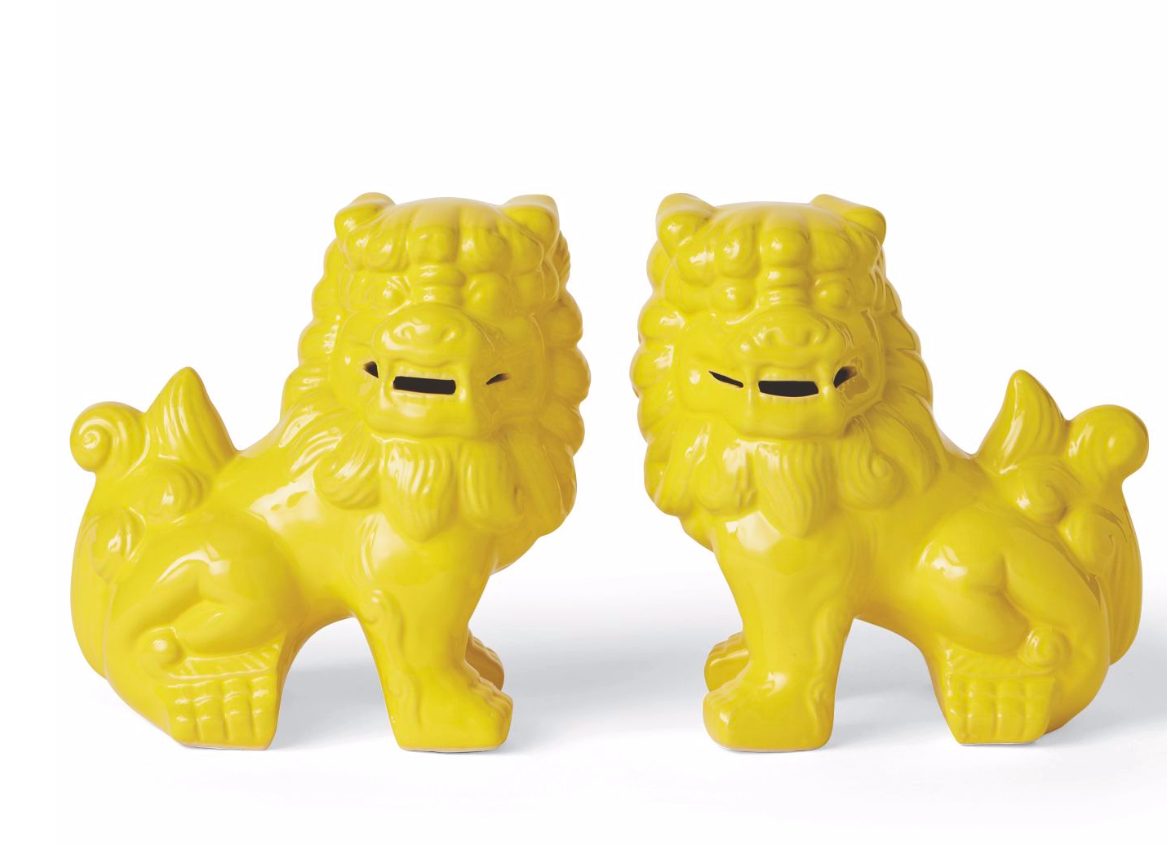 Two bright yellow glazed Chinese guardian lion figurines.