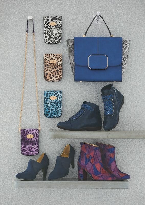 A blue faux leather bag, four animal print clutch purses with chain strap, navy shootie, laced bootie, and patchwork bootie.