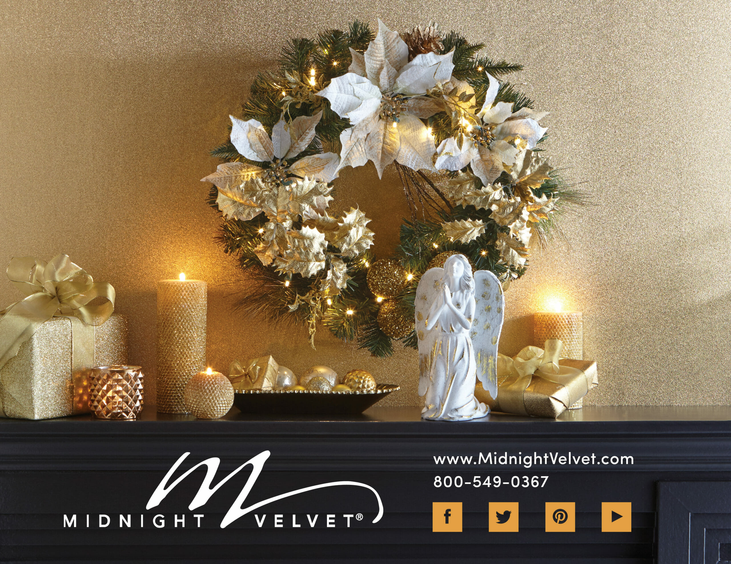 A mantle display of a lit white and gold poinsettia wreath, gold lit candles, wrapped presents, and a white praising angel.