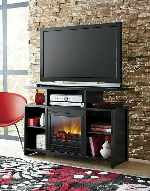 A lit black electric fireplace TV stand with open storage for receivers, books, and more, and a red, black and white rug.