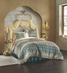 A turquoise, gray and white Grecian print bed set, with a gold bed crown and draped gold sheers, and gold side tables.