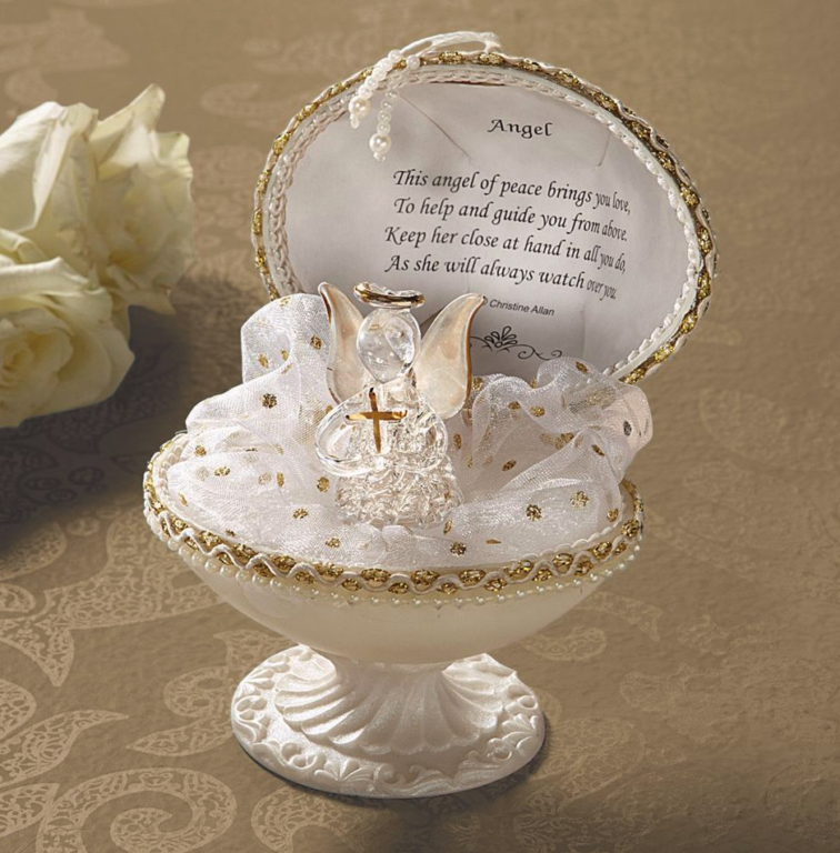 A white and gold figurine of a small glass angel in an open egg on a pedestal, with a printed Angel inscription.