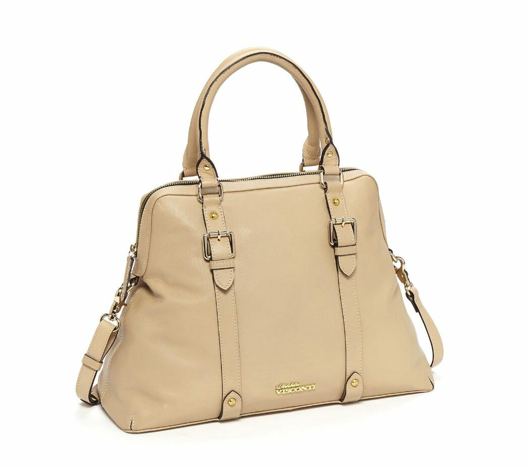 A beige faux leather bag, narrower at the top, with a full zipper and belted front straps.