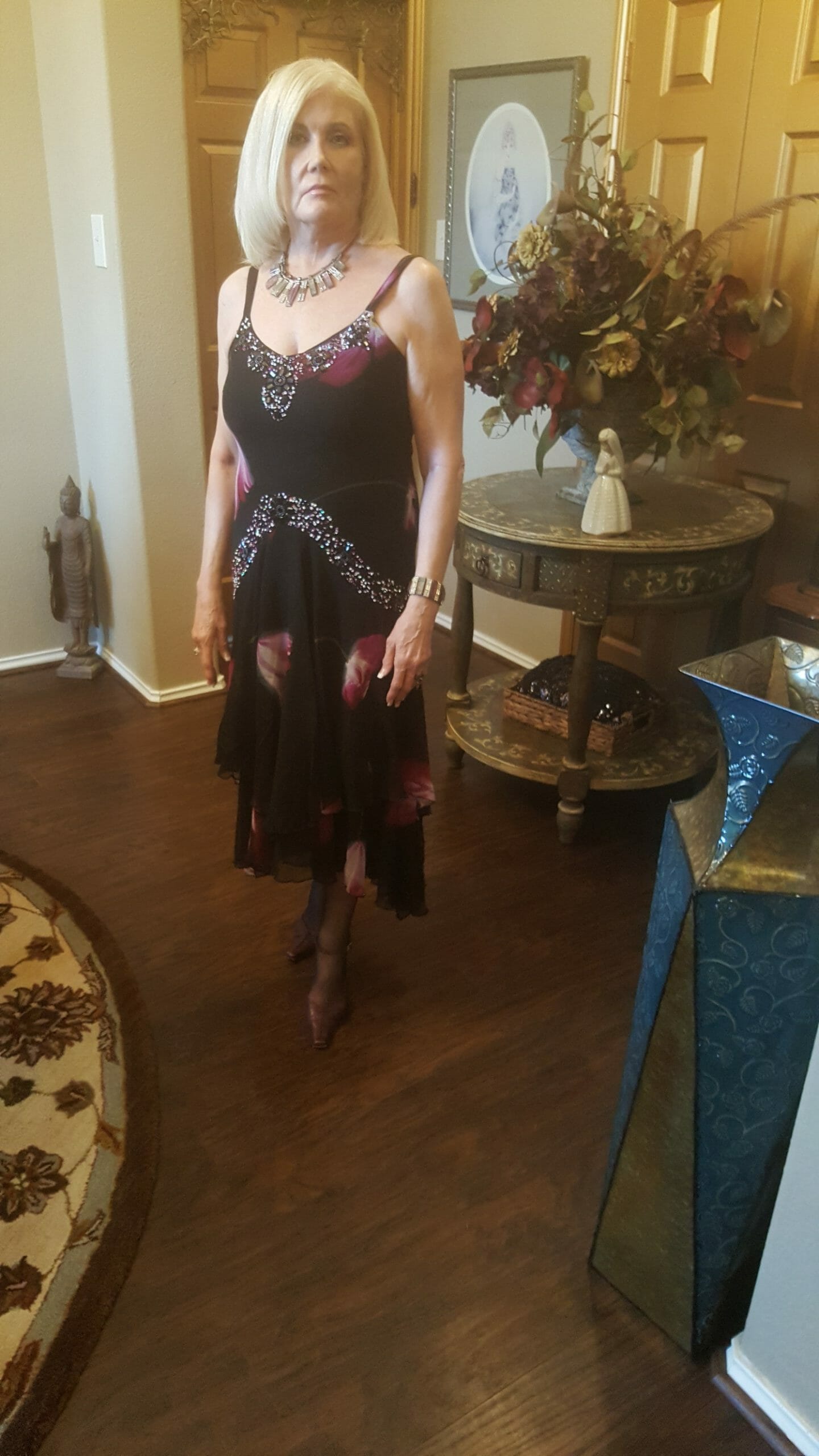A Midnight Velvet customer in a black and magenta floral print dress with beaded accents on the neckline and waist.