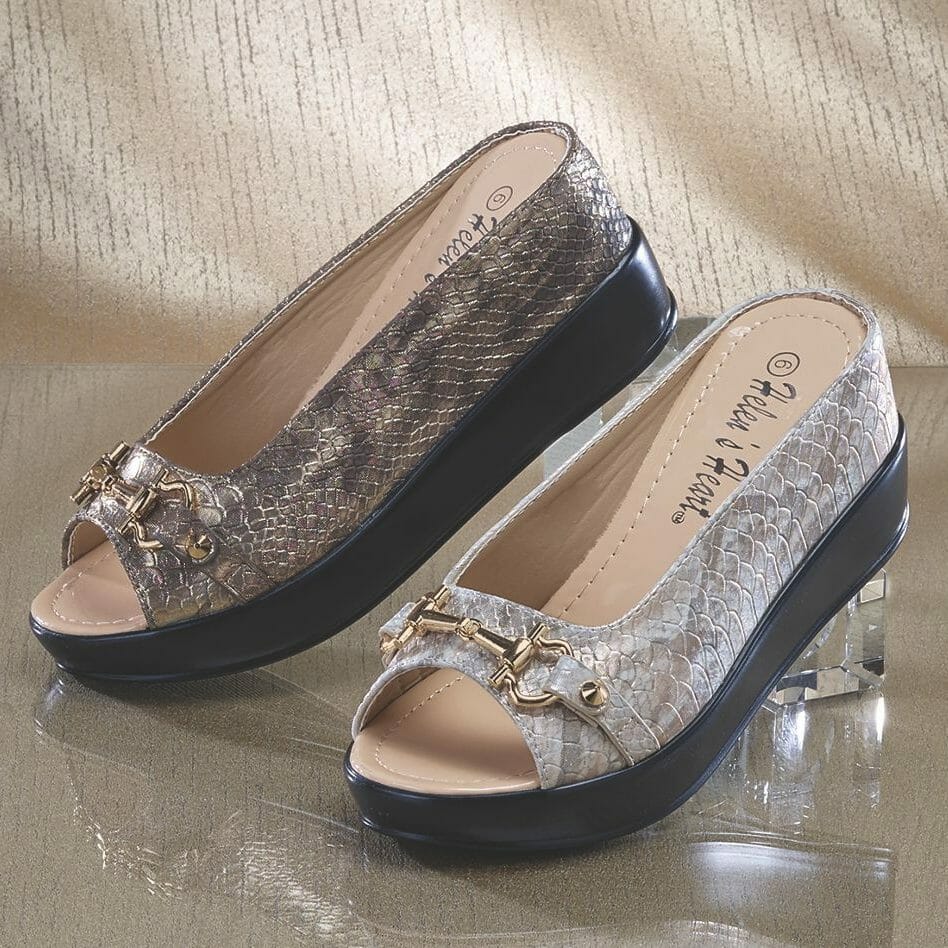 Two faux reptile skin mule shoes with open toes and gold buckle detail, one in ivory and one in tan.