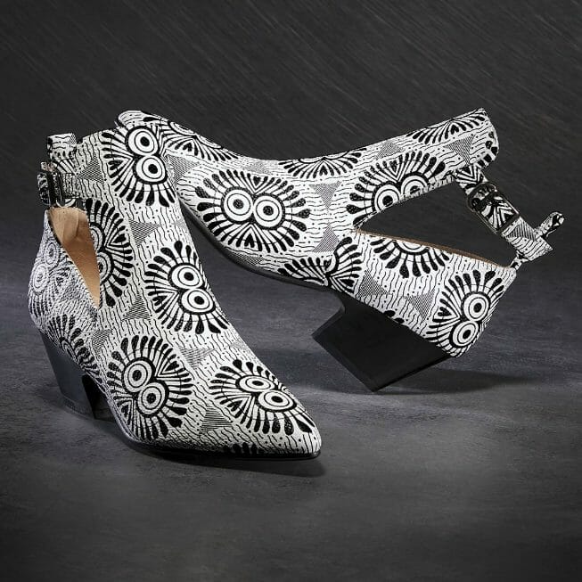 A black and white graphic print bootie, with cutout ankle area, black chunky heel, and top buckled strap.