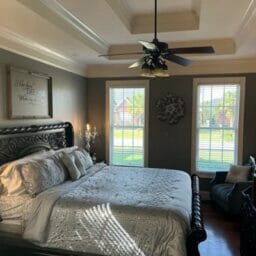 Etta Comforter Set on dark wood bedframe on hardwood floors against a grey wall in customers bedroom