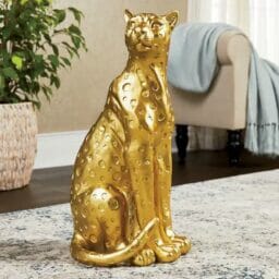 Golden Regal Leopard Statue on beige rug in front of plant and couch in living space